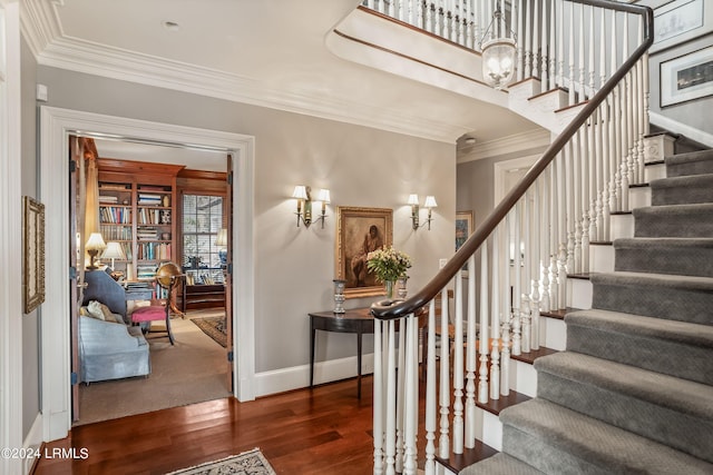 stairs featuring crown molding and wood-type flooring