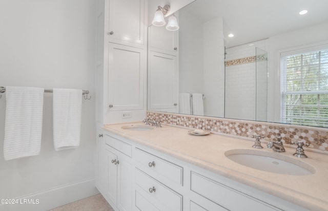 bathroom with vanity, decorative backsplash, and a shower with door