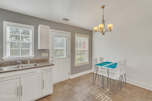 dining space featuring an inviting chandelier, a healthy amount of sunlight, and sink