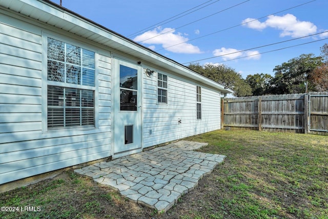 back of house with a lawn and a patio