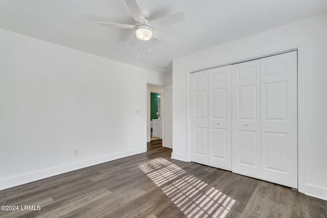 unfurnished bedroom with dark wood-type flooring, ceiling fan, and a closet