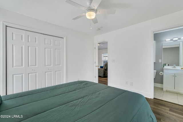 bedroom featuring dark hardwood / wood-style floors, ceiling fan, connected bathroom, and a closet