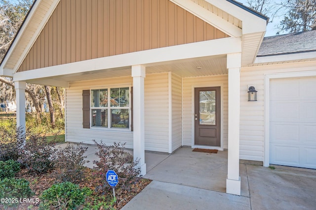 view of exterior entry with a porch and a garage