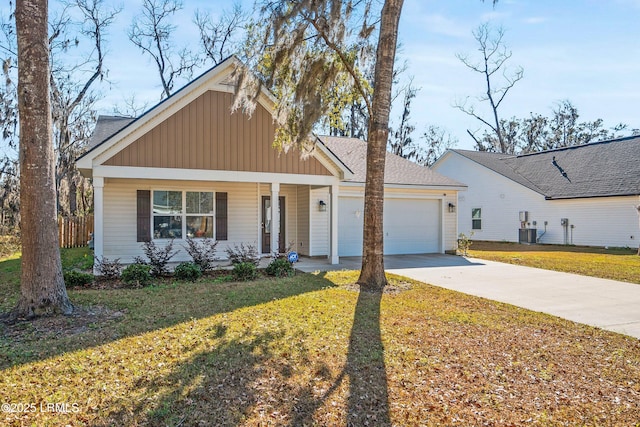 view of front of property featuring a front yard, a garage, cooling unit, and a porch