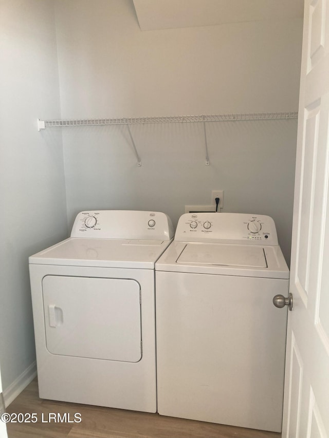 laundry area with separate washer and dryer and hardwood / wood-style floors