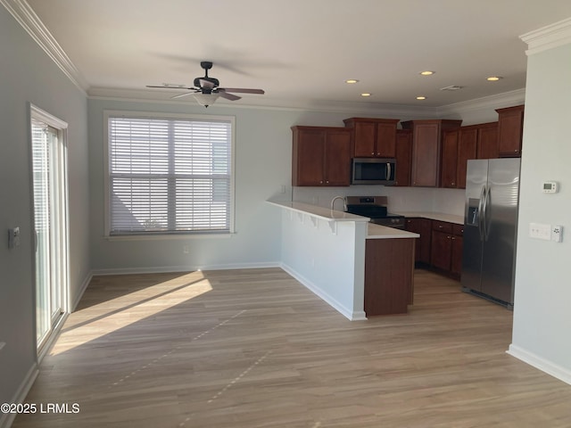 kitchen featuring ornamental molding, kitchen peninsula, ceiling fan, and appliances with stainless steel finishes