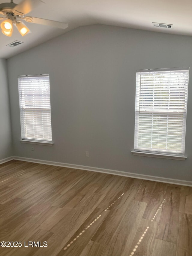 spare room featuring hardwood / wood-style flooring, vaulted ceiling, and ceiling fan