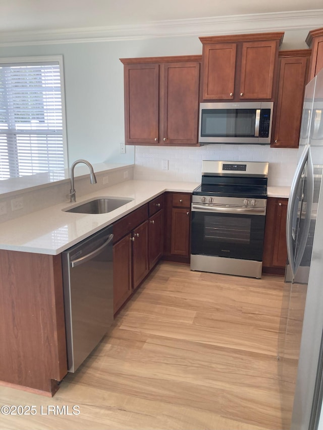 kitchen with appliances with stainless steel finishes, tasteful backsplash, sink, kitchen peninsula, and crown molding