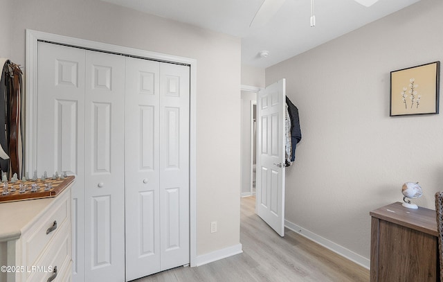 bedroom with light hardwood / wood-style floors and a closet