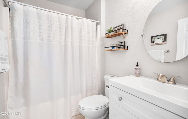 bathroom featuring walk in shower, vanity, and toilet