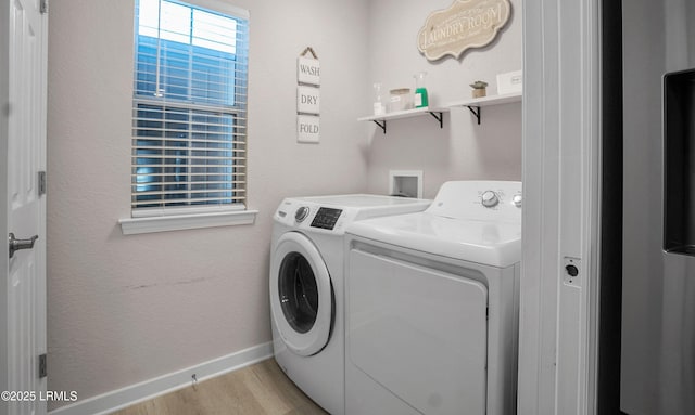 clothes washing area with washer and dryer and light hardwood / wood-style flooring