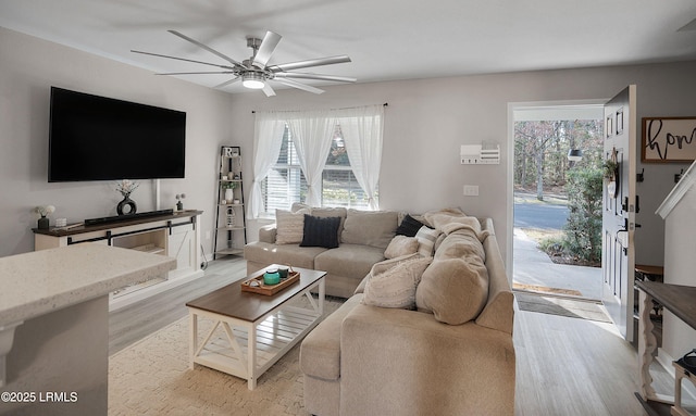 living room featuring ceiling fan and light wood-type flooring