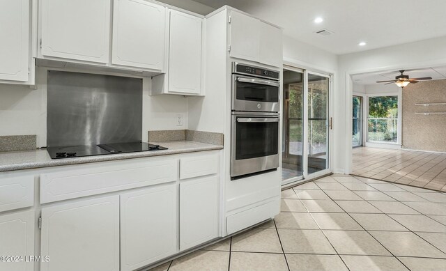 100 Thomas Sumter St, Beaufort, SC 29907 - kitchen with black electric stovetop, stainless steel double oven, white cabinetry, light tile patterned flooring, and recessed lighting