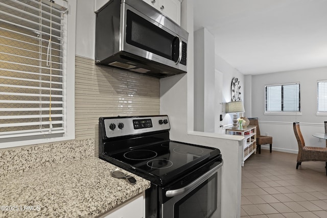 663 William Hilton Pkwy Unit 3321, Hilton Head Island, SC 29928 - kitchen featuring stainless steel appliances, light tile patterned floors, decorative backsplash, white cabinets, and light stone counters