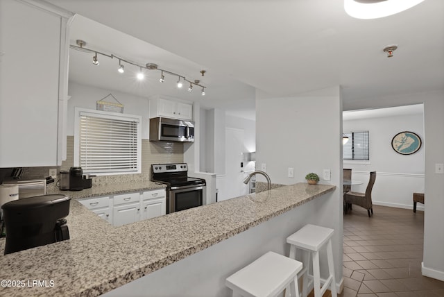 663 William Hilton Pkwy Unit 3321, Hilton Head Island, SC 29928 - kitchen with stainless steel appliances, backsplash, tile patterned floors, and white cabinetry