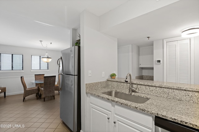 663 William Hilton Pkwy Unit 3321, Hilton Head Island, SC 29928 - kitchen featuring stainless steel appliances, a sink, white cabinets, light tile patterned floors, and light stone counters