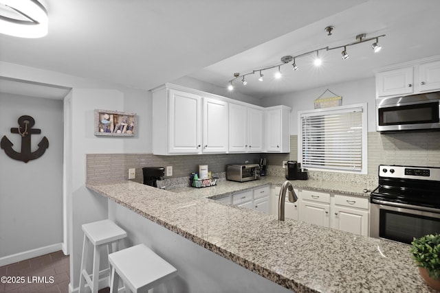 663 William Hilton Pkwy Unit 3321, Hilton Head Island, SC 29928 - kitchen with stainless steel appliances, white cabinets, tasteful backsplash, and light stone countertops