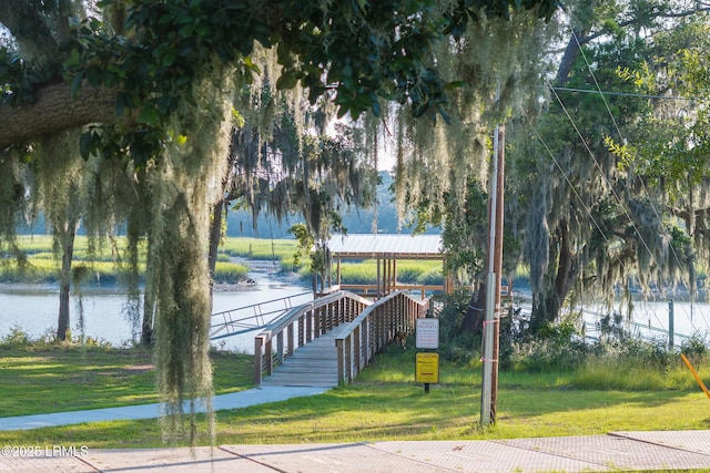 view of property's community featuring a water view and a yard