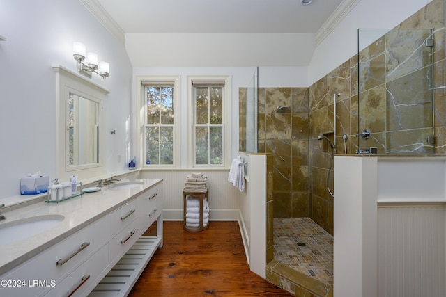 bathroom with ornamental molding, vanity, hardwood / wood-style floors, and a tile shower