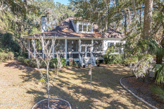 back of house with a sunroom and a lawn