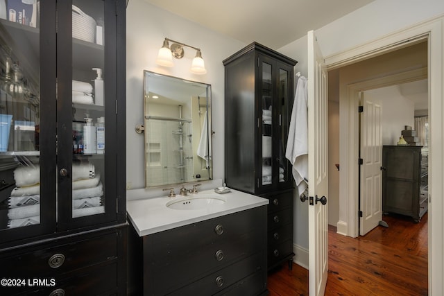 bathroom with hardwood / wood-style flooring, vanity, and a shower with shower door