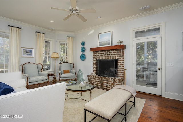 living room featuring dark hardwood / wood-style flooring, crown molding, a fireplace, and ceiling fan