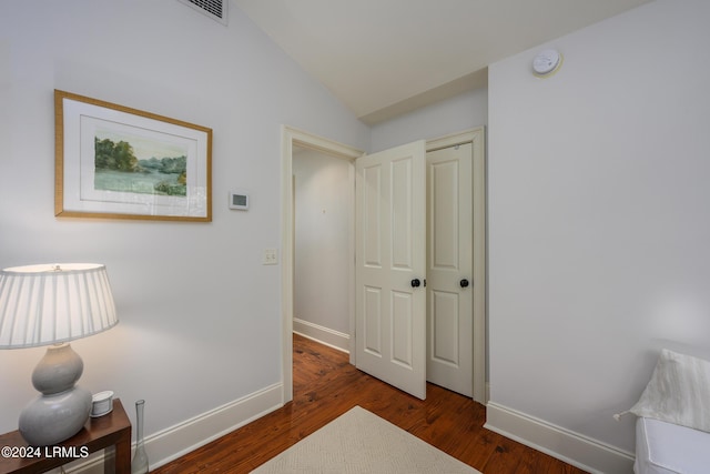 hallway featuring lofted ceiling and dark hardwood / wood-style floors