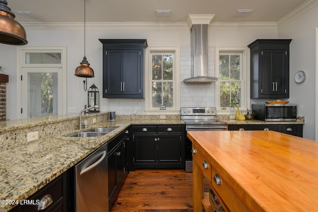 kitchen with sink, hanging light fixtures, stainless steel appliances, light stone countertops, and wall chimney range hood