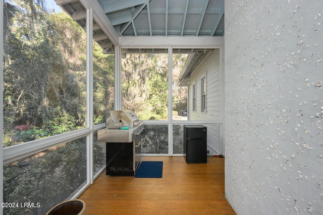 unfurnished sunroom featuring vaulted ceiling