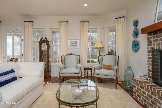 living room with crown molding, a brick fireplace, and hardwood / wood-style floors