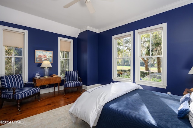 bedroom with wood-type flooring, crown molding, and ceiling fan