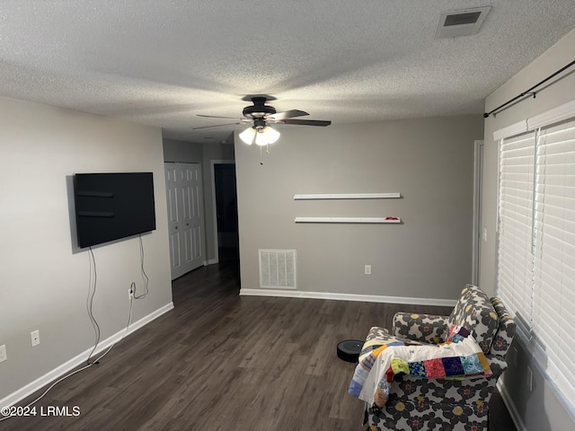 unfurnished bedroom with dark hardwood / wood-style floors, a textured ceiling, ceiling fan, and a closet