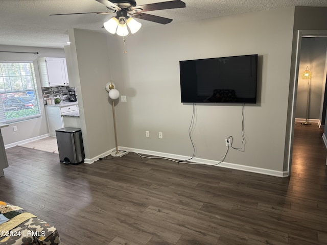 unfurnished living room featuring ceiling fan, a textured ceiling, and dark hardwood / wood-style flooring