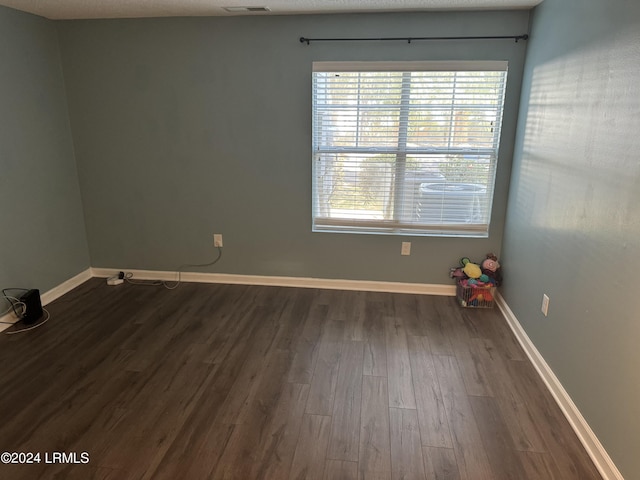 unfurnished room with dark wood-type flooring