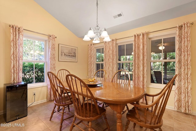 dining room with an inviting chandelier, light tile patterned floors, visible vents, lofted ceiling, and baseboards