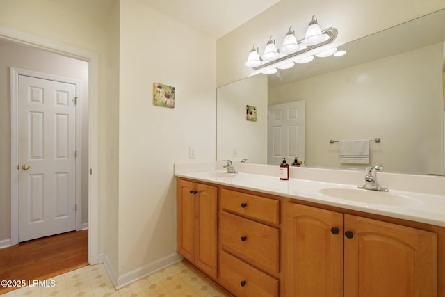 full bathroom featuring tile patterned floors, double vanity, a sink, and baseboards