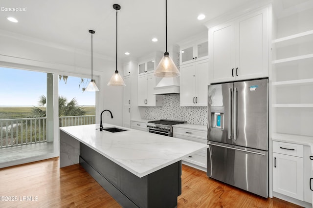 kitchen featuring custom exhaust hood, stainless steel appliances, light wood-style floors, white cabinetry, and a sink