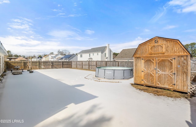 exterior space with a fenced in pool and a storage shed