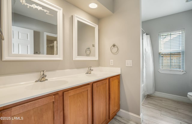 full bathroom with vanity, shower / bath combo with shower curtain, and toilet