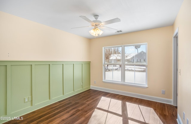 unfurnished room with dark wood-type flooring and ceiling fan