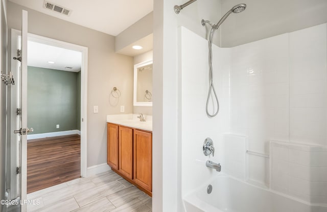 bathroom featuring washtub / shower combination and vanity