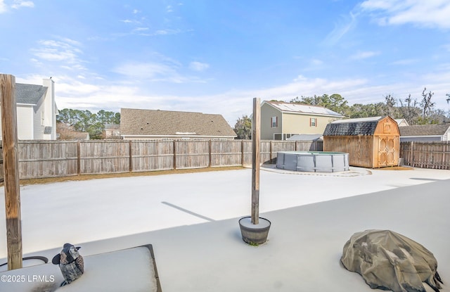 view of patio featuring a fenced in pool and a shed