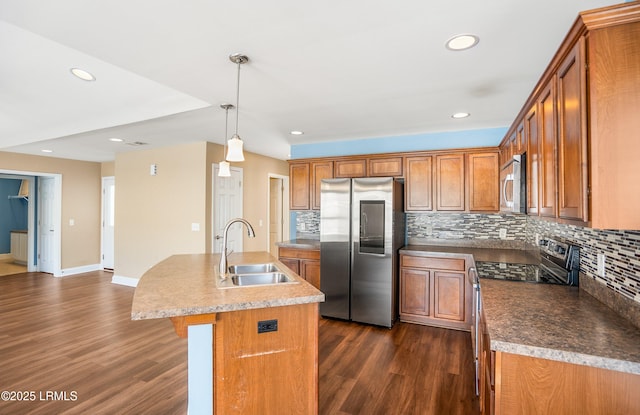 kitchen with sink, a center island with sink, appliances with stainless steel finishes, dark hardwood / wood-style floors, and pendant lighting