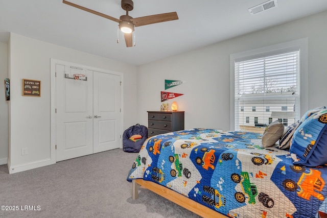 bedroom with baseboards, visible vents, ceiling fan, carpet flooring, and a closet