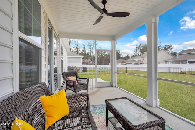 sunroom with a ceiling fan and a residential view