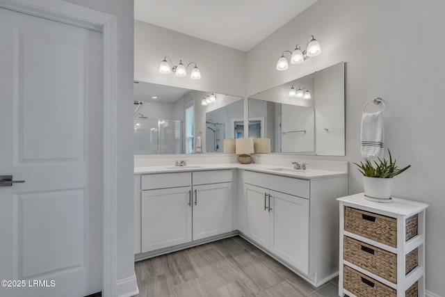 full bathroom featuring double vanity, a sink, and a shower stall