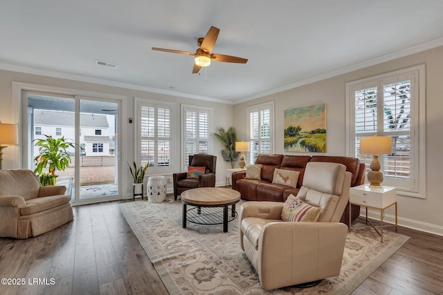 living area with a healthy amount of sunlight, visible vents, and crown molding