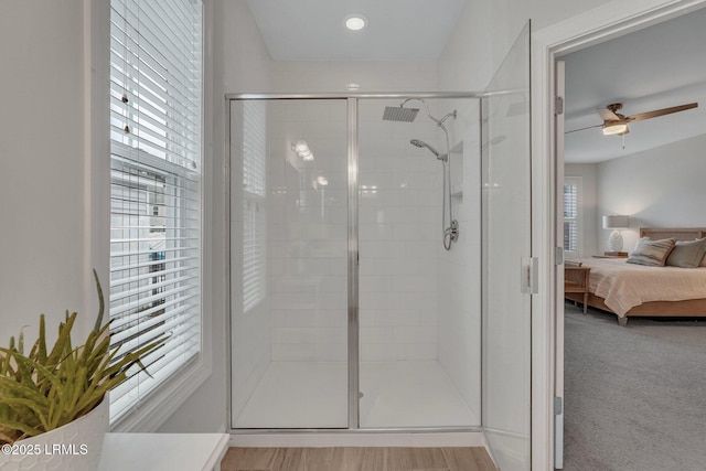 ensuite bathroom with a healthy amount of sunlight, a stall shower, ensuite bath, and a ceiling fan