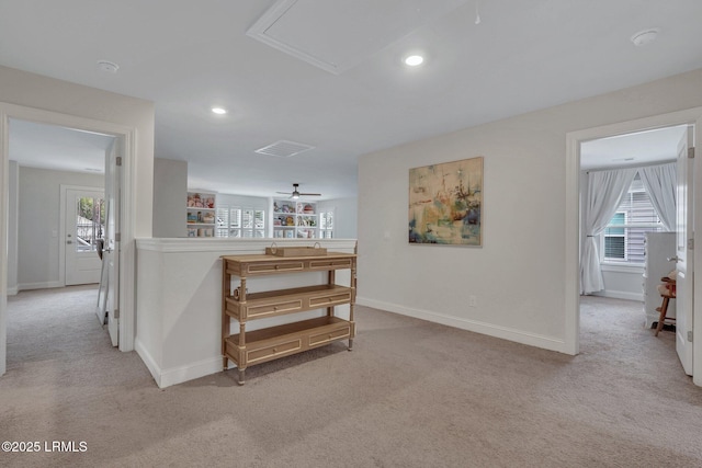 hallway featuring a wealth of natural light, light colored carpet, and baseboards