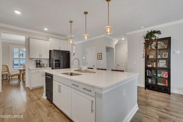 kitchen featuring a center island with sink, high end fridge, light wood-style floors, white cabinetry, and a sink